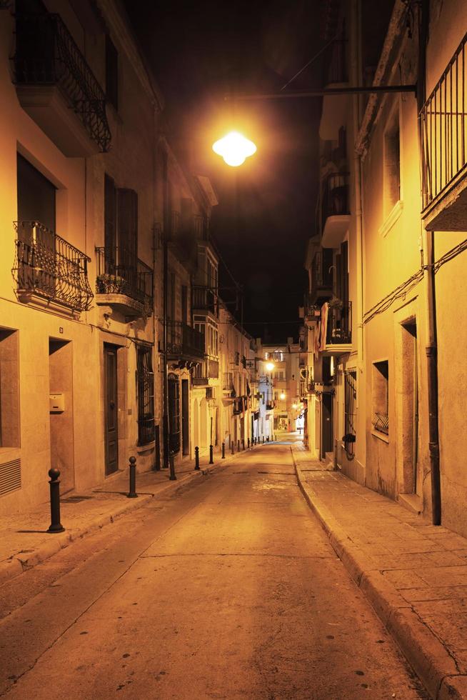 verlaten straten van de oude stad staken een lantaarn aan foto