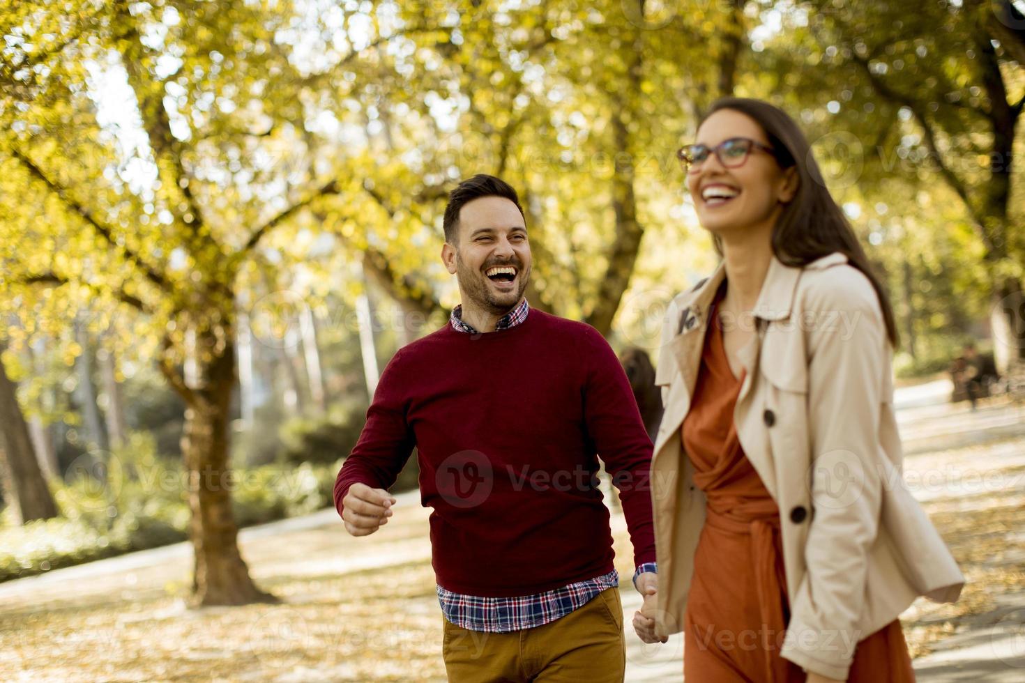 jonge vrouw en man wandelen in stadspark hand in hand? foto