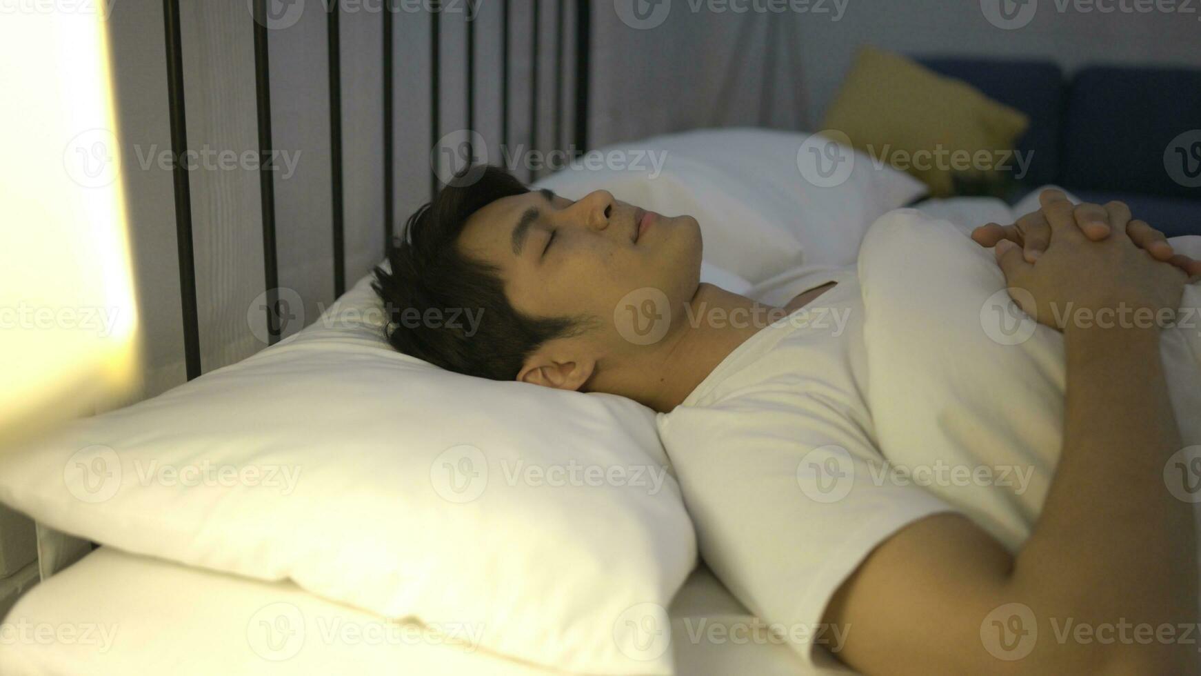 een jong Aziatisch Mens slaapt comfortabel met een zacht kussen. foto