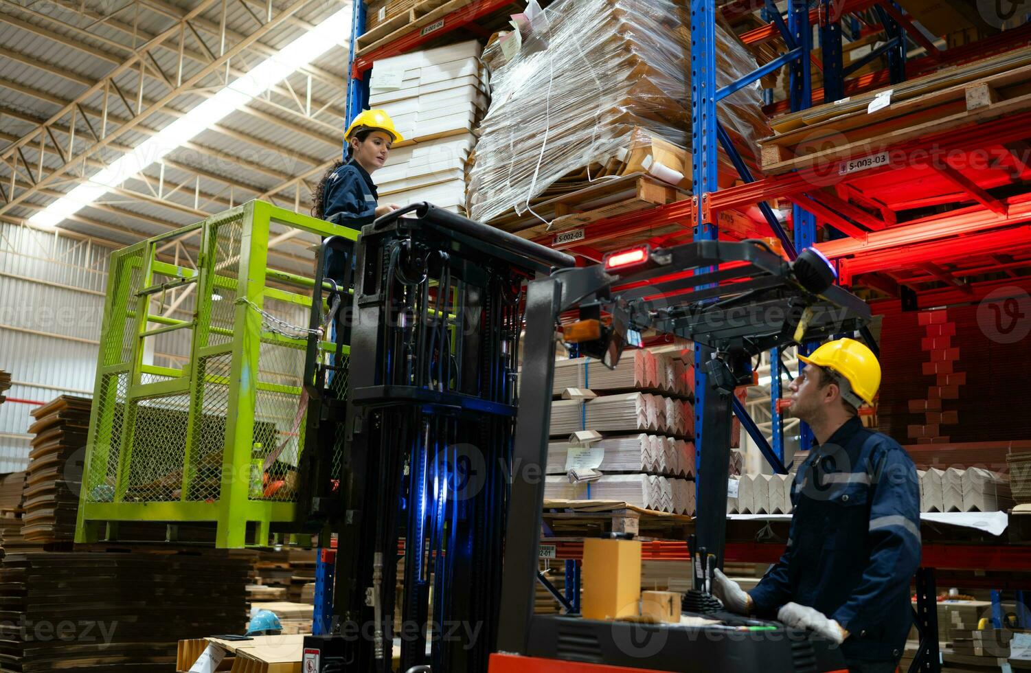 magazijn arbeiders gebruik makend van heftruck naar controleren en tellen in een groot magazijn. deze is een groot papier pakket opslagruimte en distributie magazijn. foto