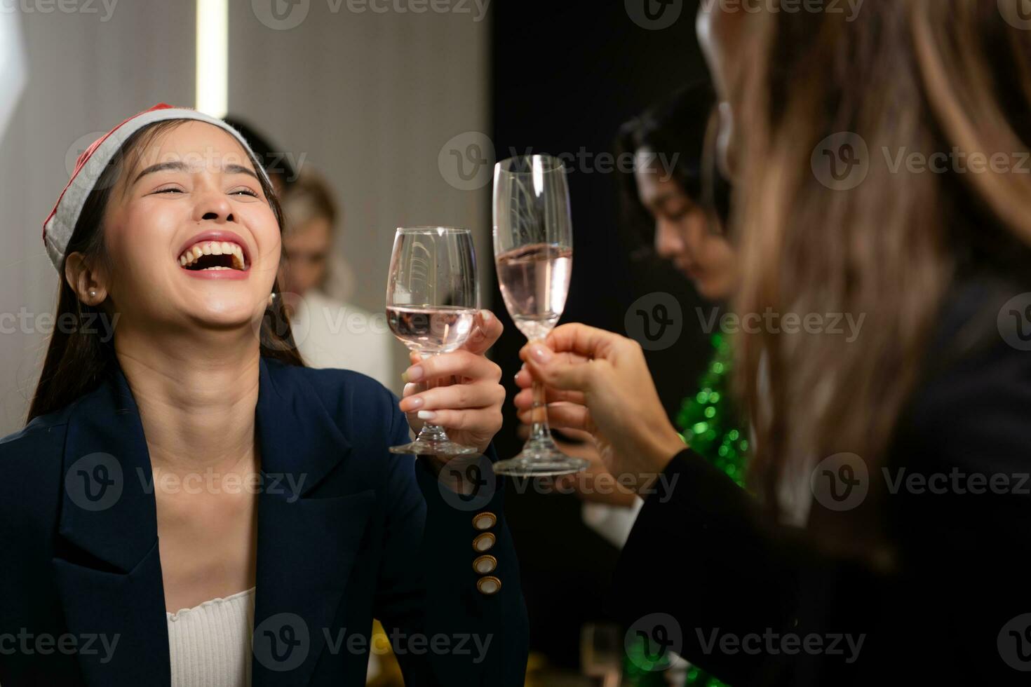 Aziatisch vrouw in de kerstman hoed gerinkel bril van Champagne Bij partij foto