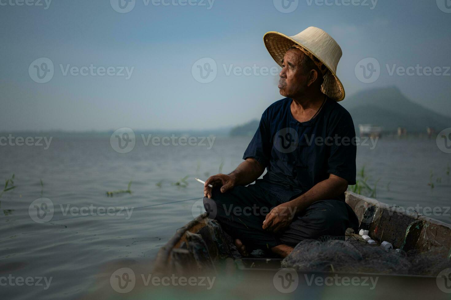 een visser ontspant in een boot Aan de meer terwijl roken. foto