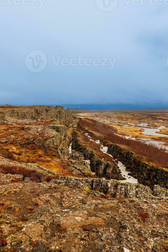 rotsachtig heuvels nordic landschap in thingvellir nationaal park, mooi natuurlijk landschap met rots formaties en vallei met kliffen. majestueus IJslands oriëntatiepunten met berg muur, hoogland. foto