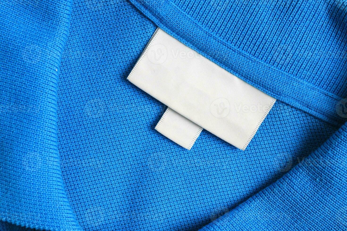 blanco wit wasserij zorg kleren etiket Aan blauw overhemd kleding stof structuur achtergrond foto