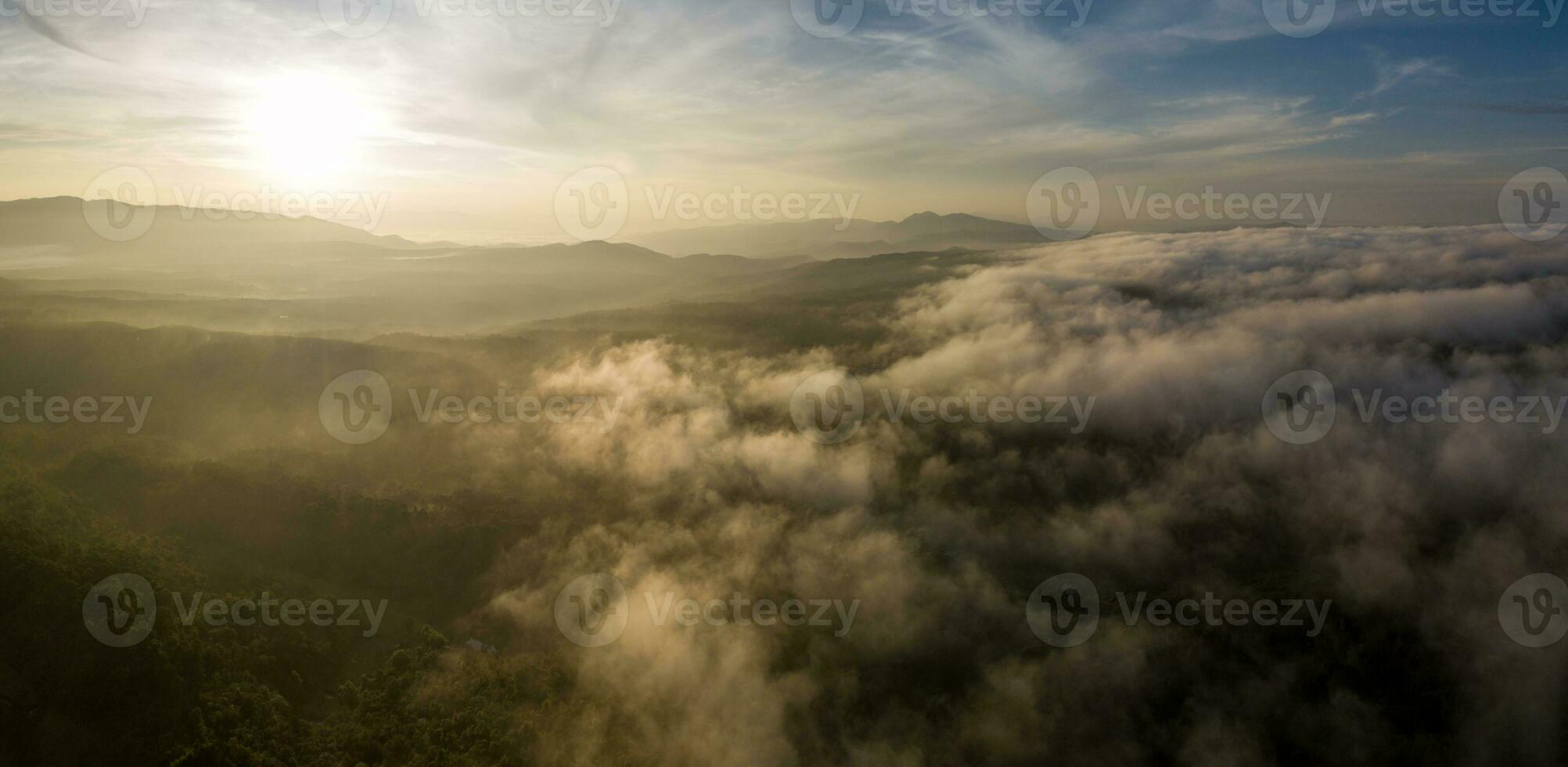 antenne visie van ochtend- zonsopkomst van tropisch regenwoud Bij dageraad met nevelig en mistig wolk gedurende zomer voor buitenshuis berg vallei landschap foto