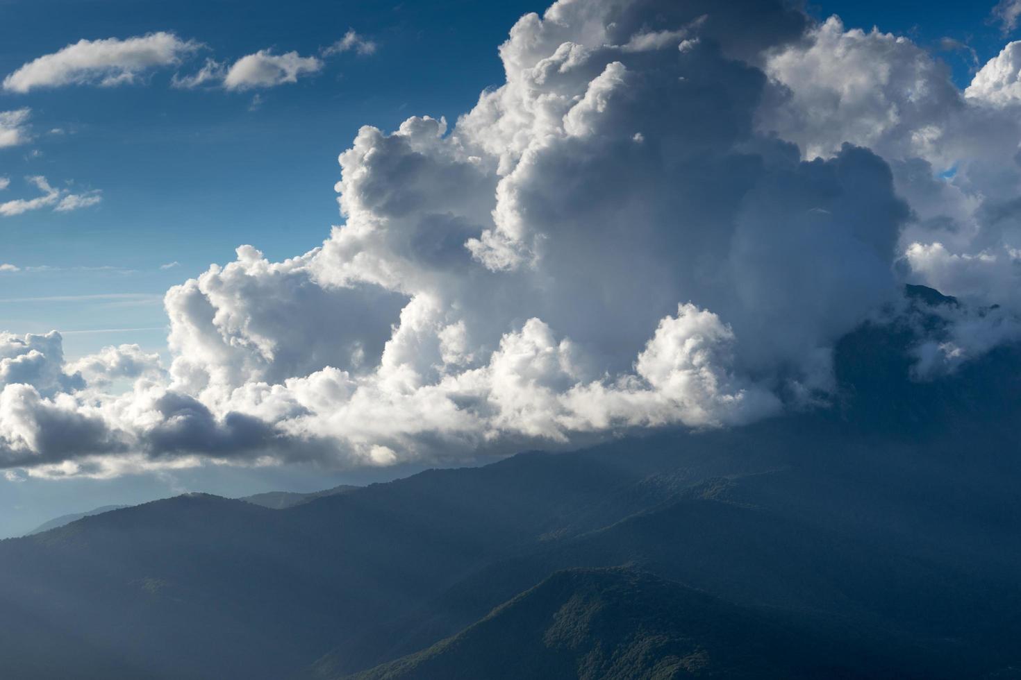 berglandschap op de achtergrond van de bewolkte lucht en zonnestralen foto