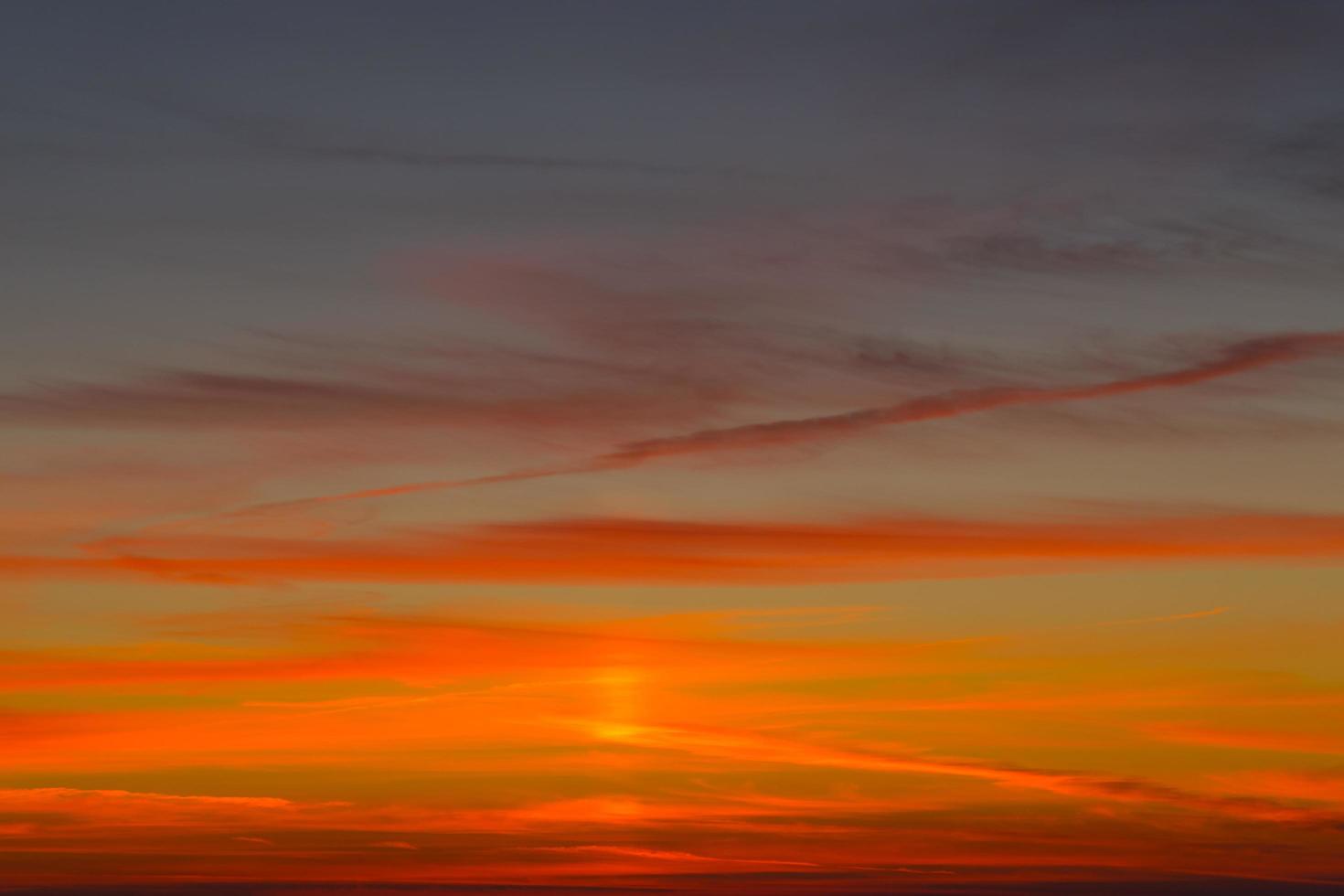 heldere oranjerode zonsondergang op een donkerblauwe hemel. foto