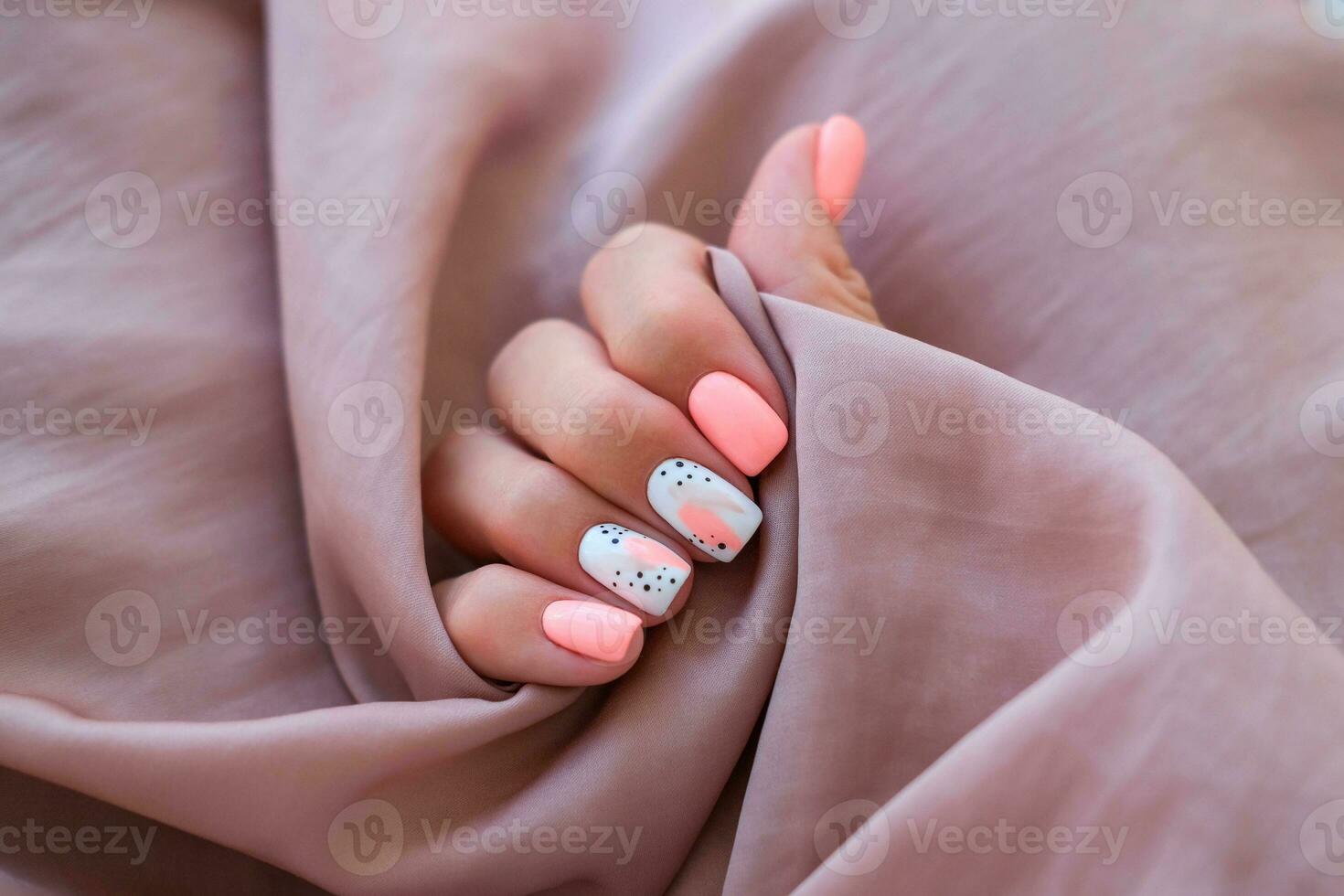 Dames - een hand- met een mooi manicure houdt een zijde kleding stof. voorjaar tendens, roze nagels, tekening Aan nagels met gel Pools, schellak. kopiëren ruimte. foto