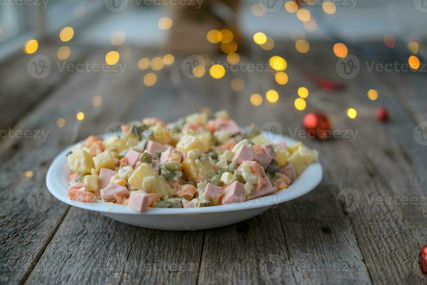 eigengemaakt nieuw jaar is olivier salade Aan een houten achtergrond. een bord van traditioneel Russisch Kerstmis salade. foto