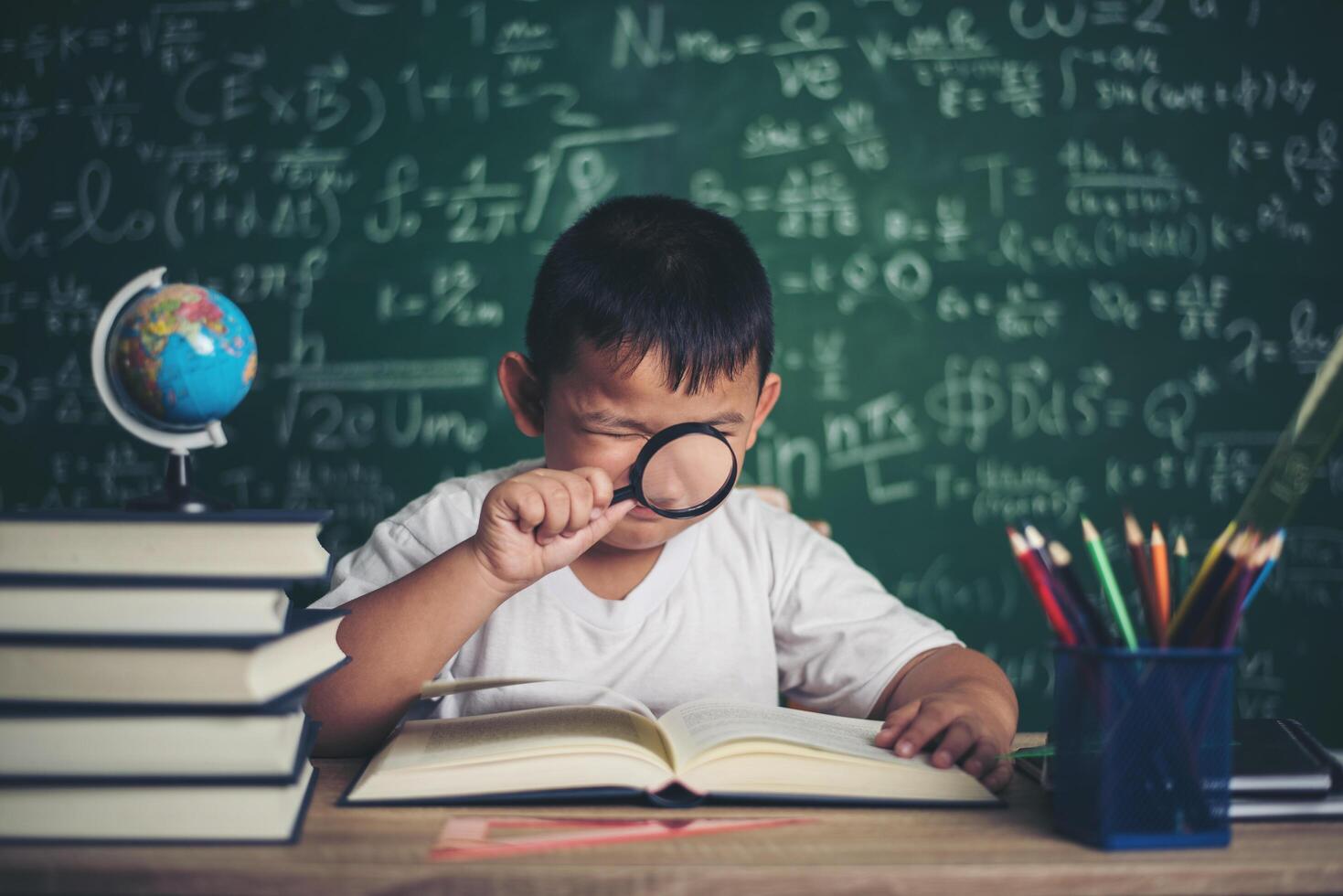 kind observeren of studeren educatief wereldbolmodel in de klas. foto