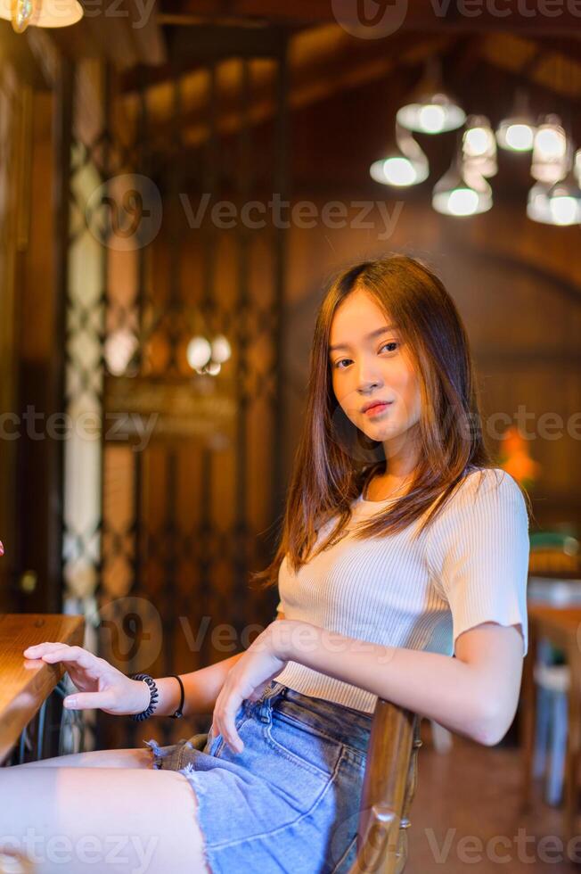 mooie vrouw zittend in een stoel in een café foto