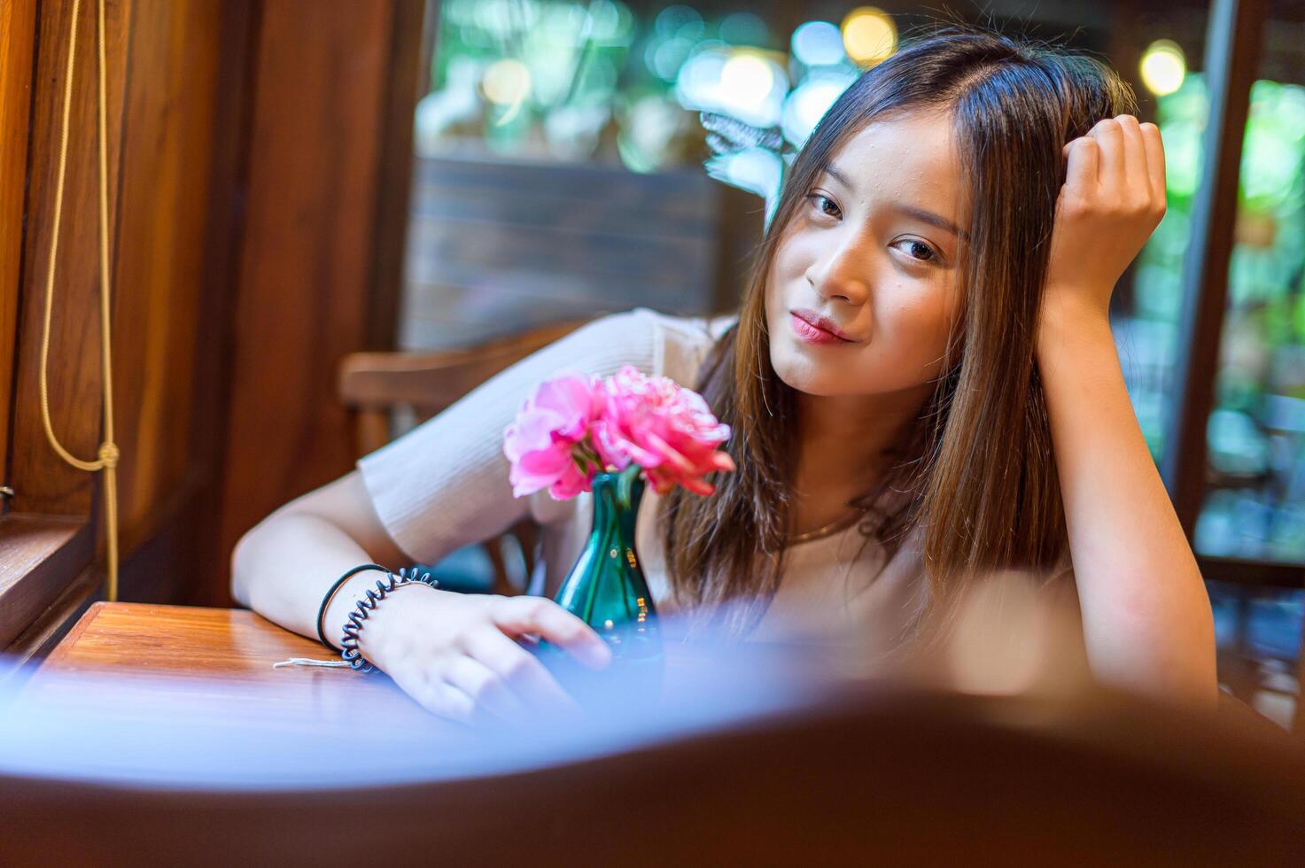 mooie vrouw zittend in een stoel in een café foto