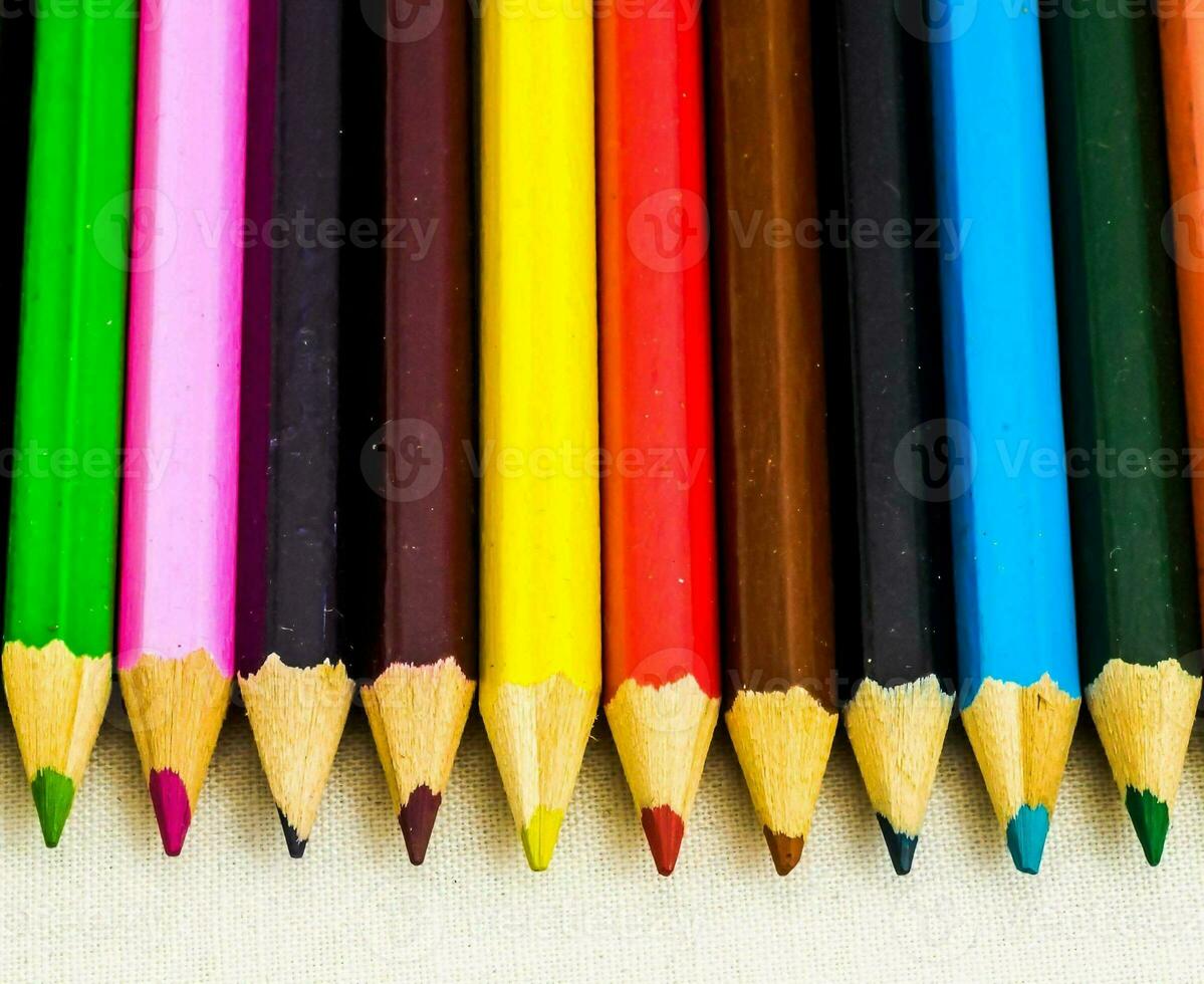 een rij van gekleurde potloden Aan een wit oppervlakte foto