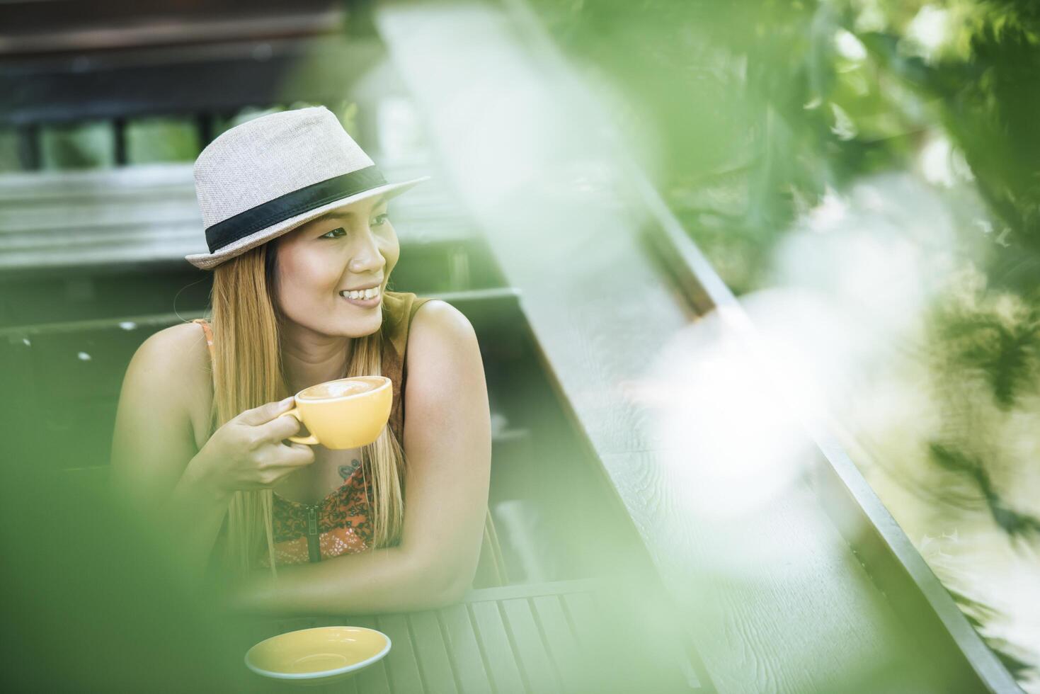 gelukkige jonge vrouw met latte koffie in de ochtend foto