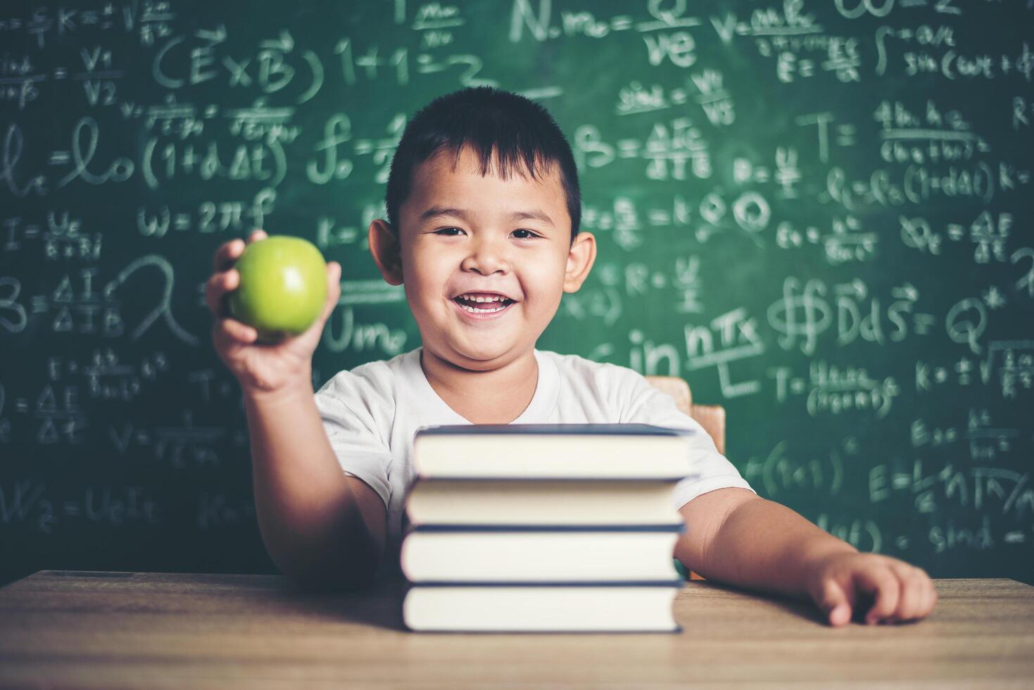 jongen met een appel in de klas foto