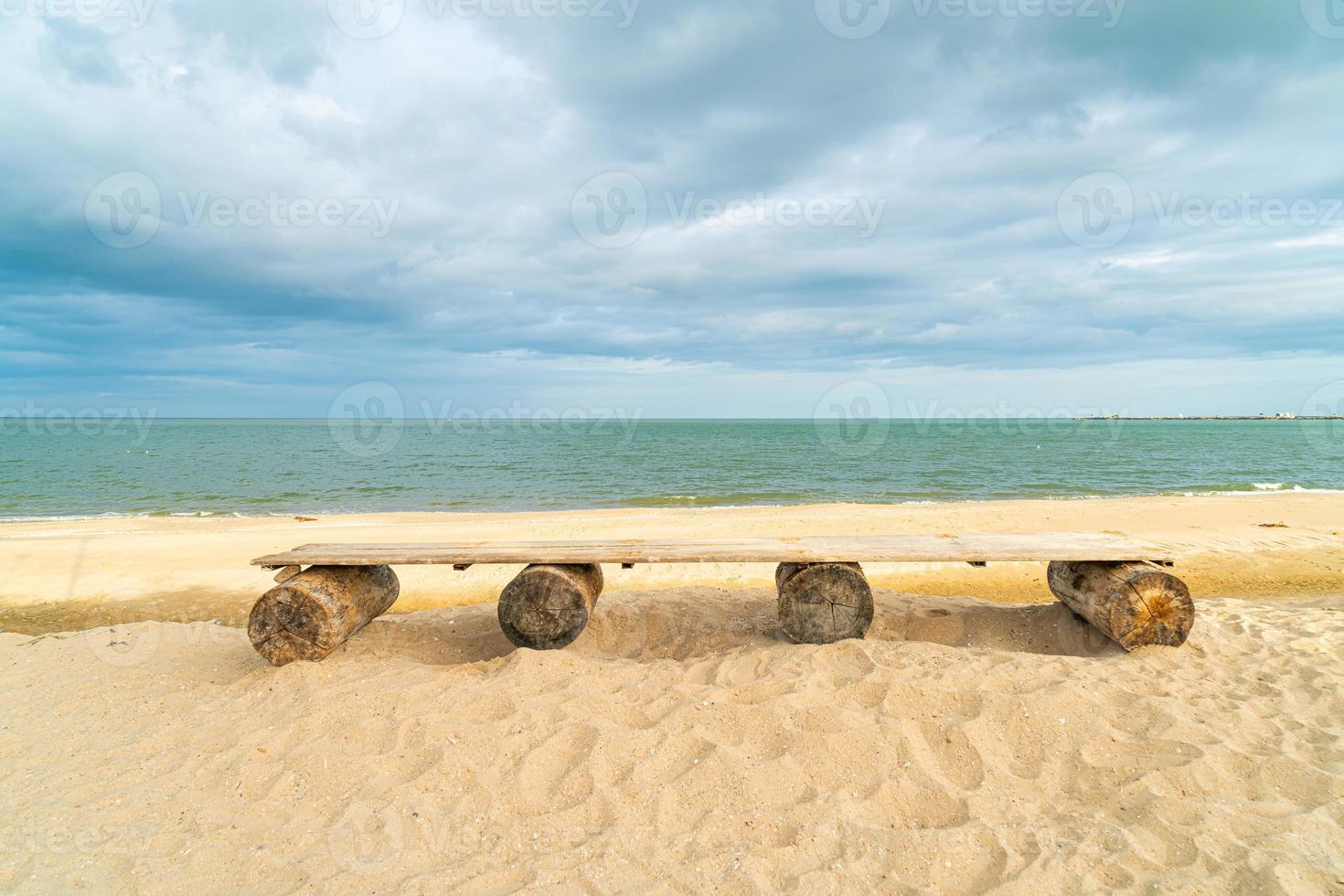 houten bank op strand met zee strand achtergrond foto