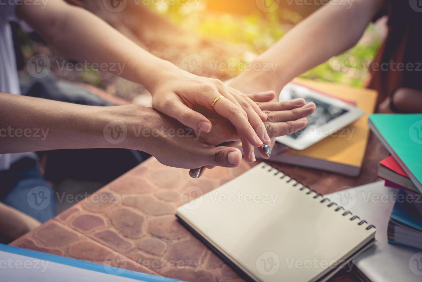 close-up handen van mensen die hun handen op elkaar zetten en stapelen foto