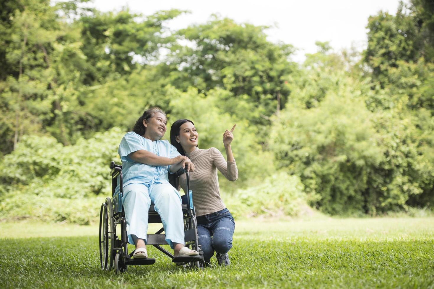 kleindochter praten met haar grootmoeder zittend op rolstoel foto
