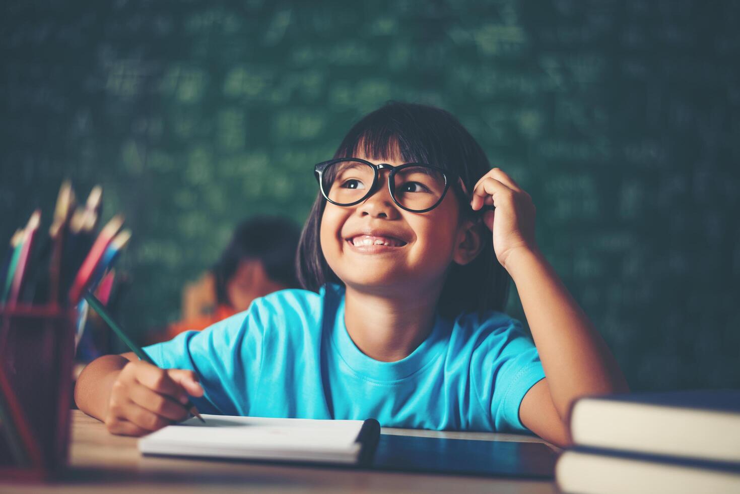 attent meisje met boek in de buurt van een schoolbestuur foto