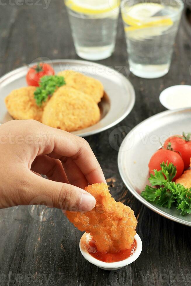 dompelen krokant nugget Aan pittig saus foto