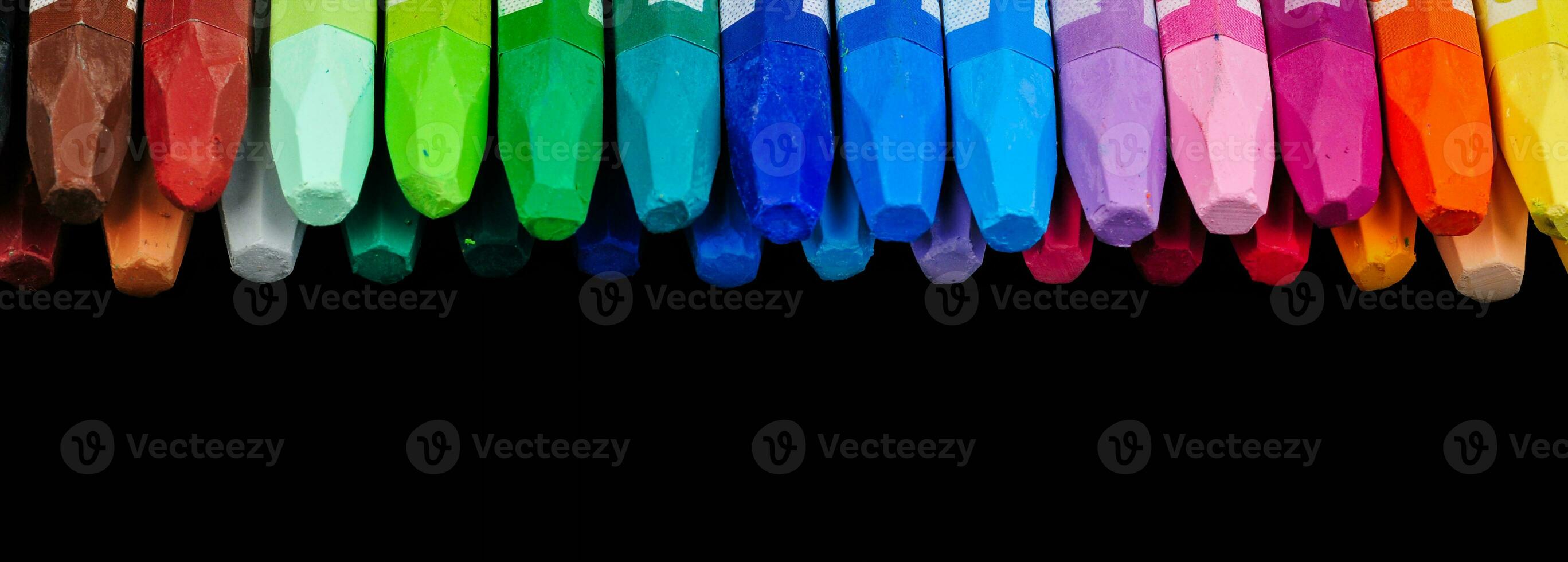 een verzameling van netjes geregeld krijt stokjes zichtbaar van bovenstaand in een rij van kleurrijk kleuren foto