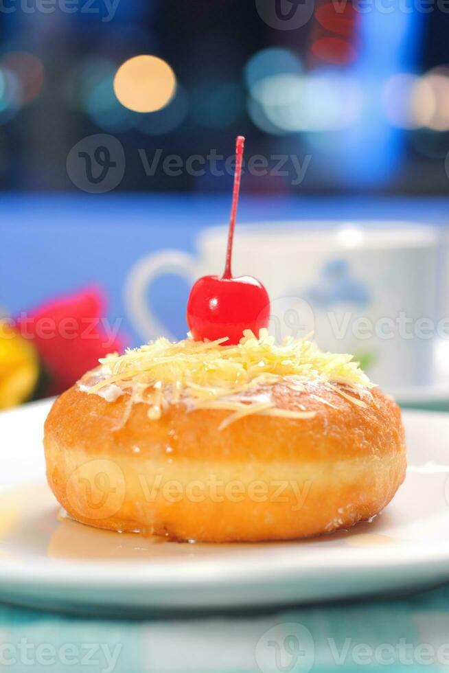 donuts versierd met kersen en besprenkeld met kaas en gepoederd suiker foto