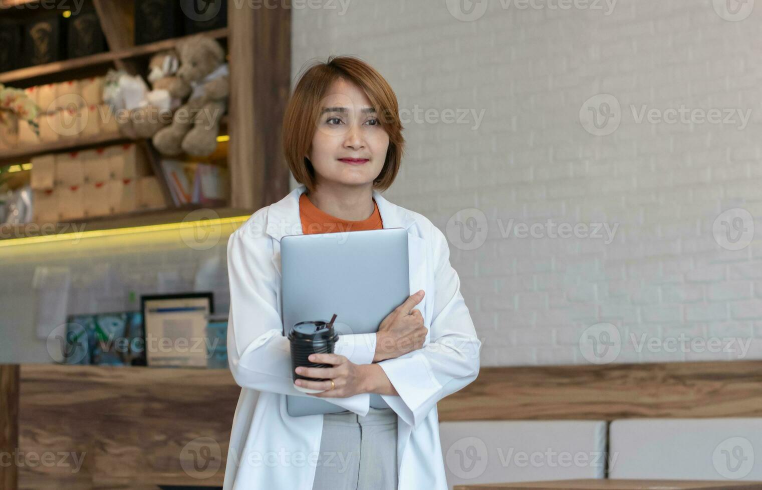 zakenvrouw vervelend wit pak jasje Holding laptop en buying koffie meenemen heet drinken wandelen uit de cafe voor Gaan vergadering klant, levensstijl werk concept. foto