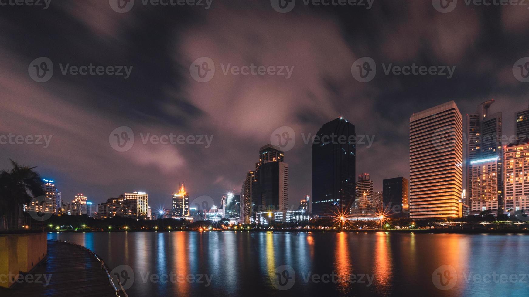 grote stad in het nachtleven met weerspiegeling van watergolf foto