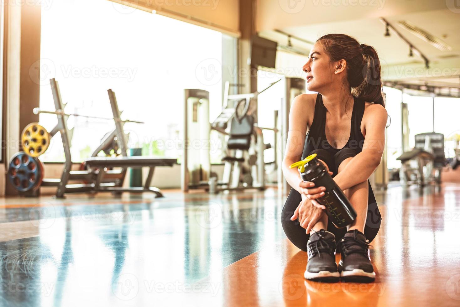 sport vrouw ontspannen rusten na training of oefening in fitness gym foto