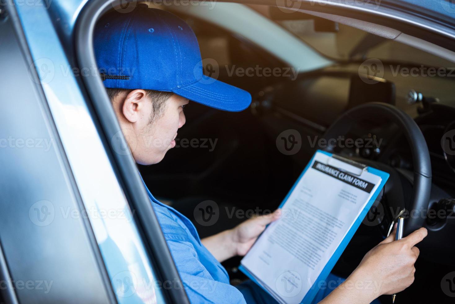 monteur die klembord vasthoudt en in de auto controleert op onderhoud foto