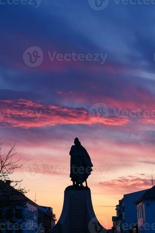 monument standbeeld van leif Erikson, een beroemd IJslands ontdekkingsreiziger in voorkant van hoofd meevoeren de hallgrimskirkja kerk in de zonsondergang foto