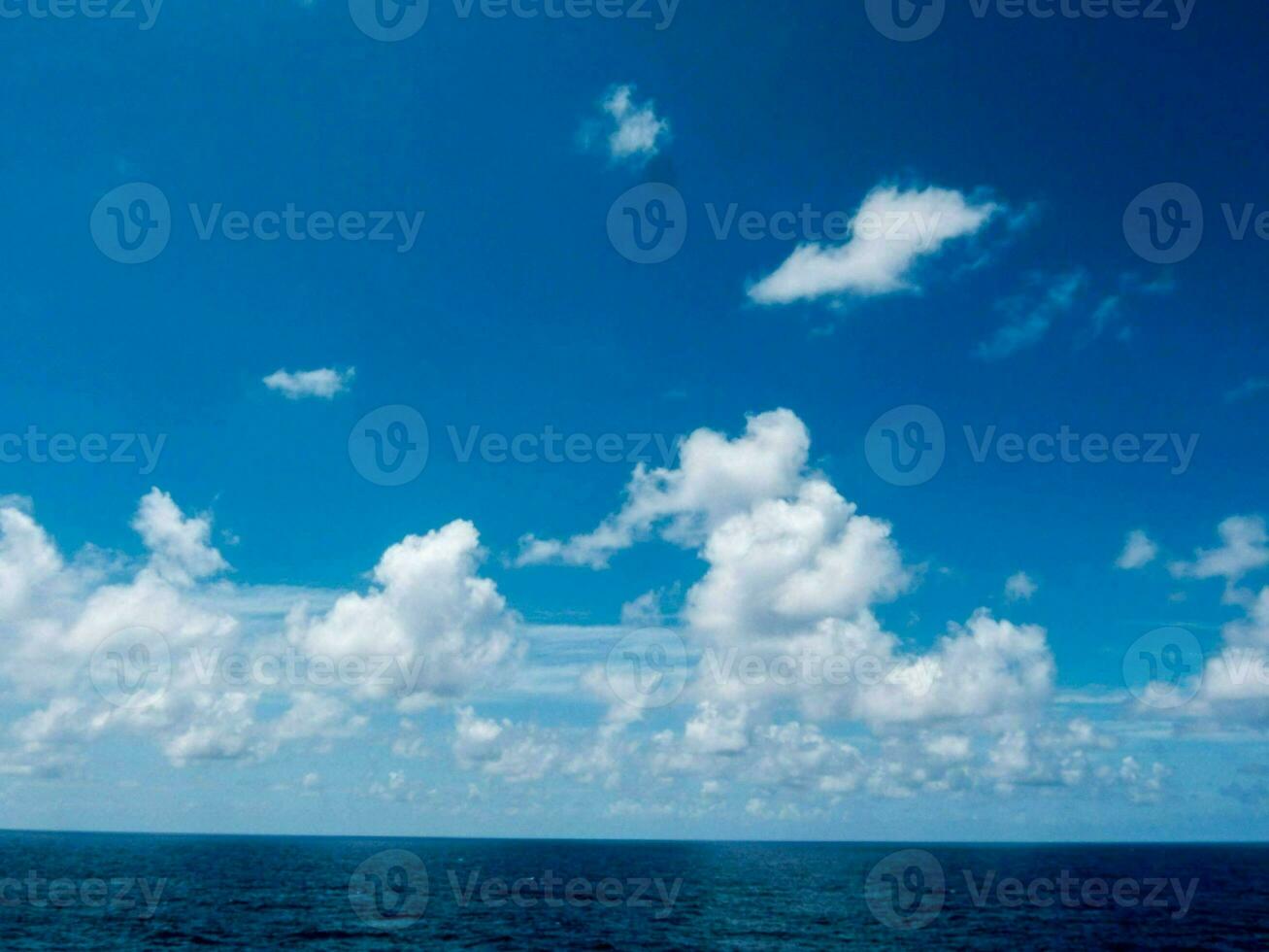 een blauw lucht met wolken over- de oceaan foto