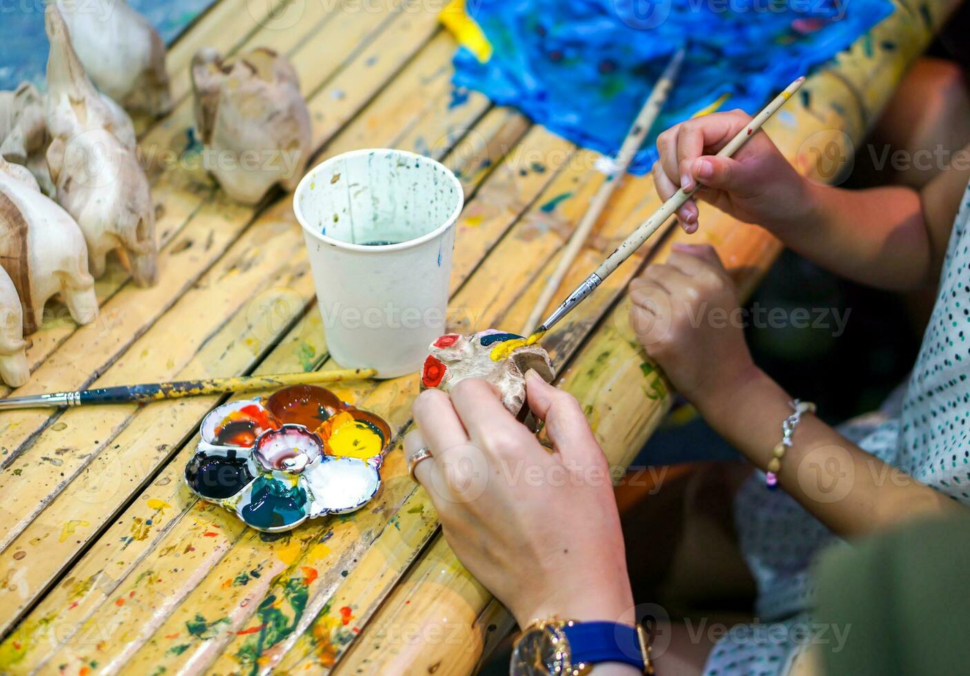 close-up handen van kunststudenten die penseelstudie houden en verf leren op houten dierenpop in het kunstklaslokaal. foto