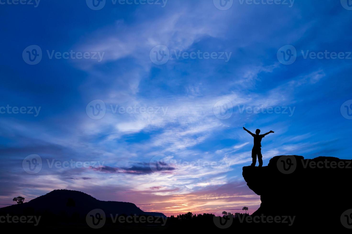 silhouet van een man op de rots bij zonsondergang foto