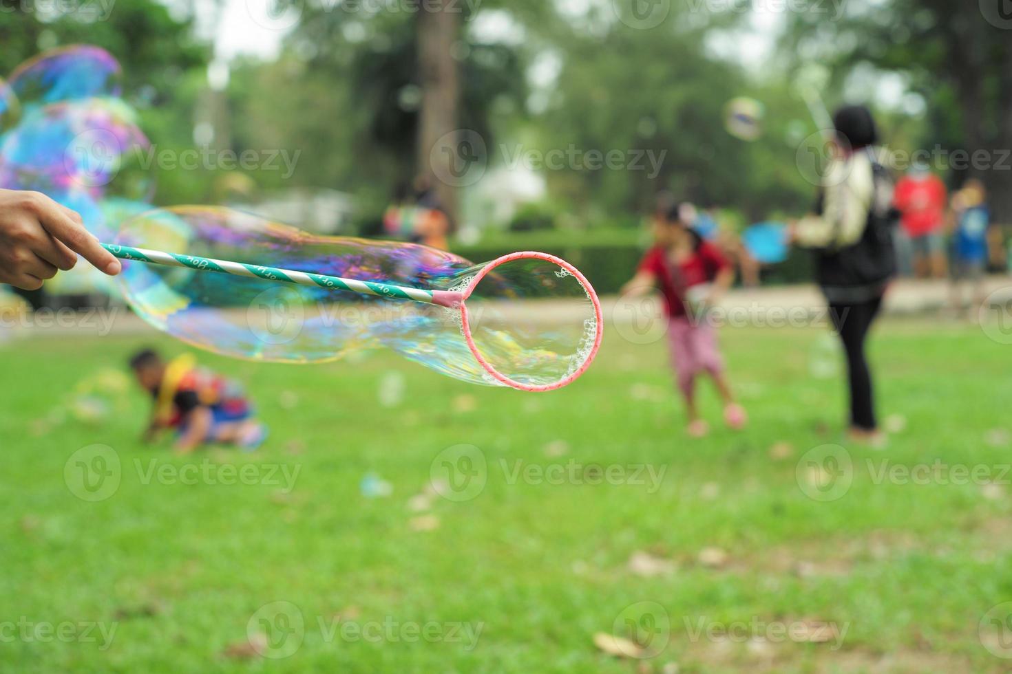 hand houdt de plastic ring vast om zeepbellen te maken foto