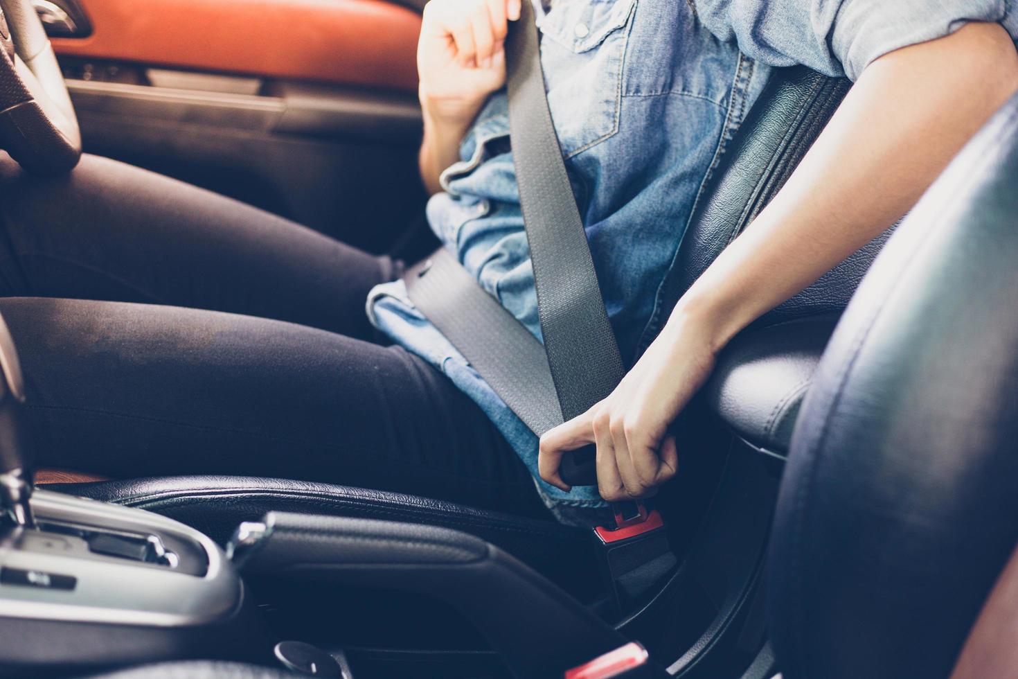 aziatische vrouw die veiligheidsgordel vastmaakt in de auto, veiligheidsconcept foto