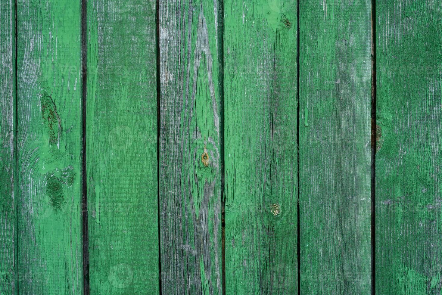 houten groene achtergrond, gekleurd door de leeftijd en wat verf die eraf bladert foto