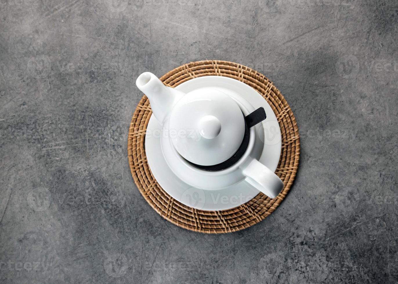 witte porseleinen theekop en theepot, afternoon tea-tafelsetting foto