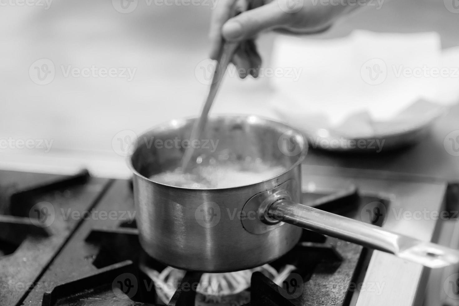 chef-kok kookt eten, maaltijd, in de keuken foto