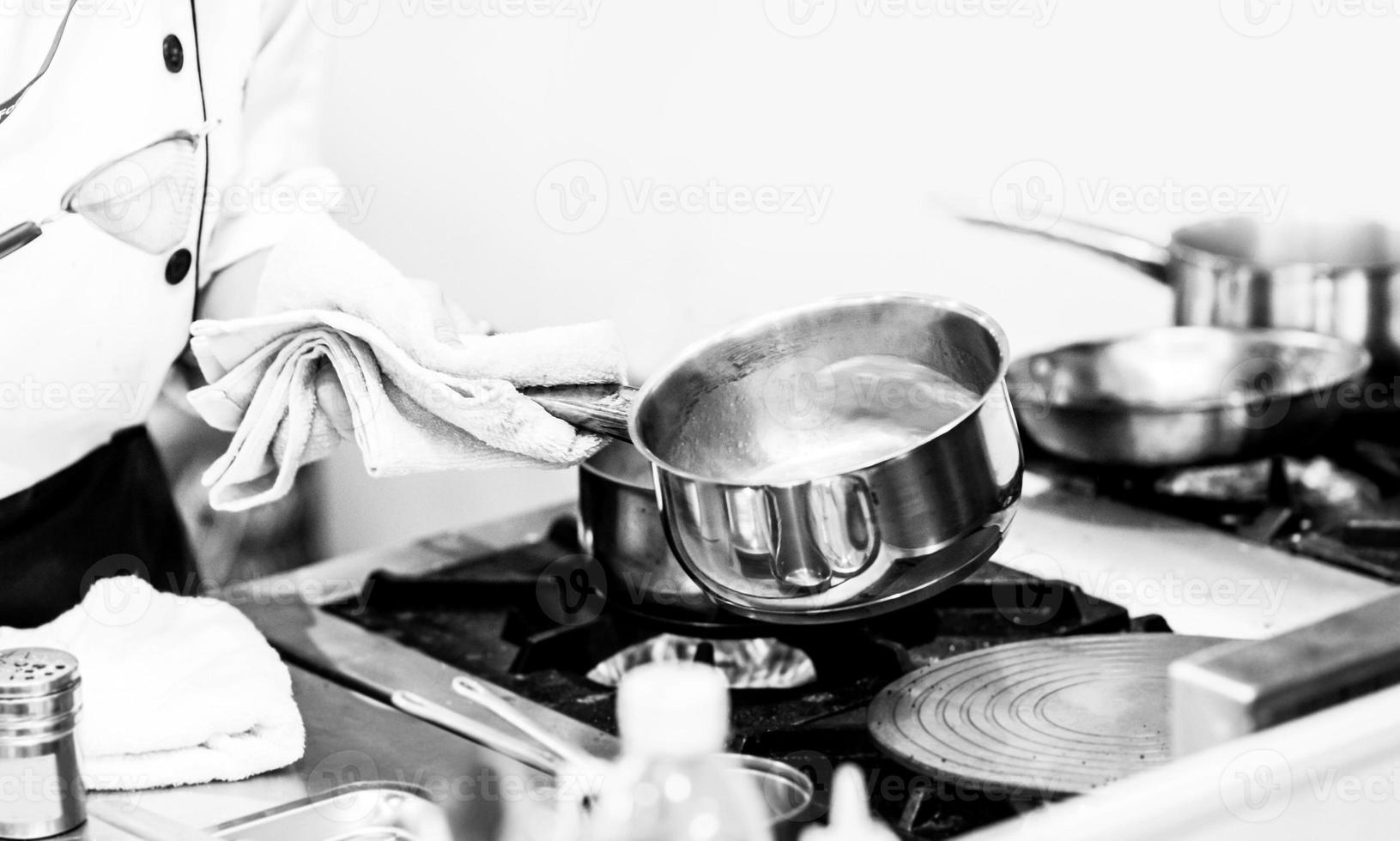 chef-kok kookt eten, maaltijd, in de keuken foto