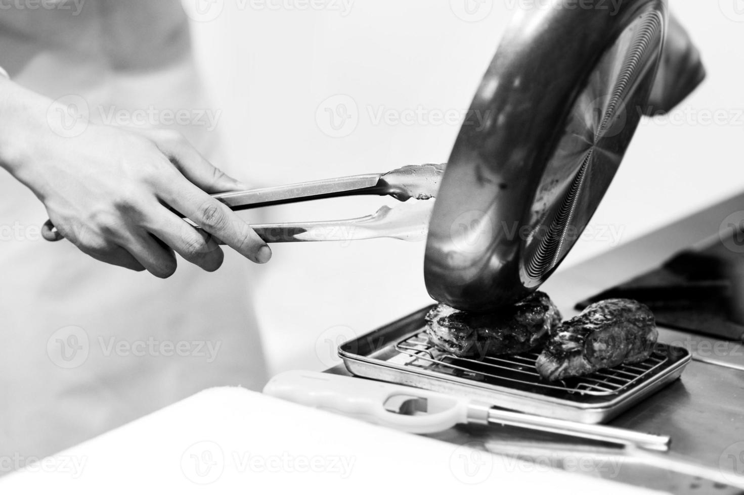 chef-kok kookt eten, maaltijd, in de keuken foto