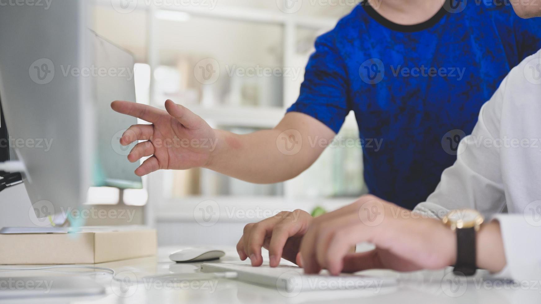 programmaanalisten die naar een computerscherm wijzen om programmeurs te begeleiden. foto