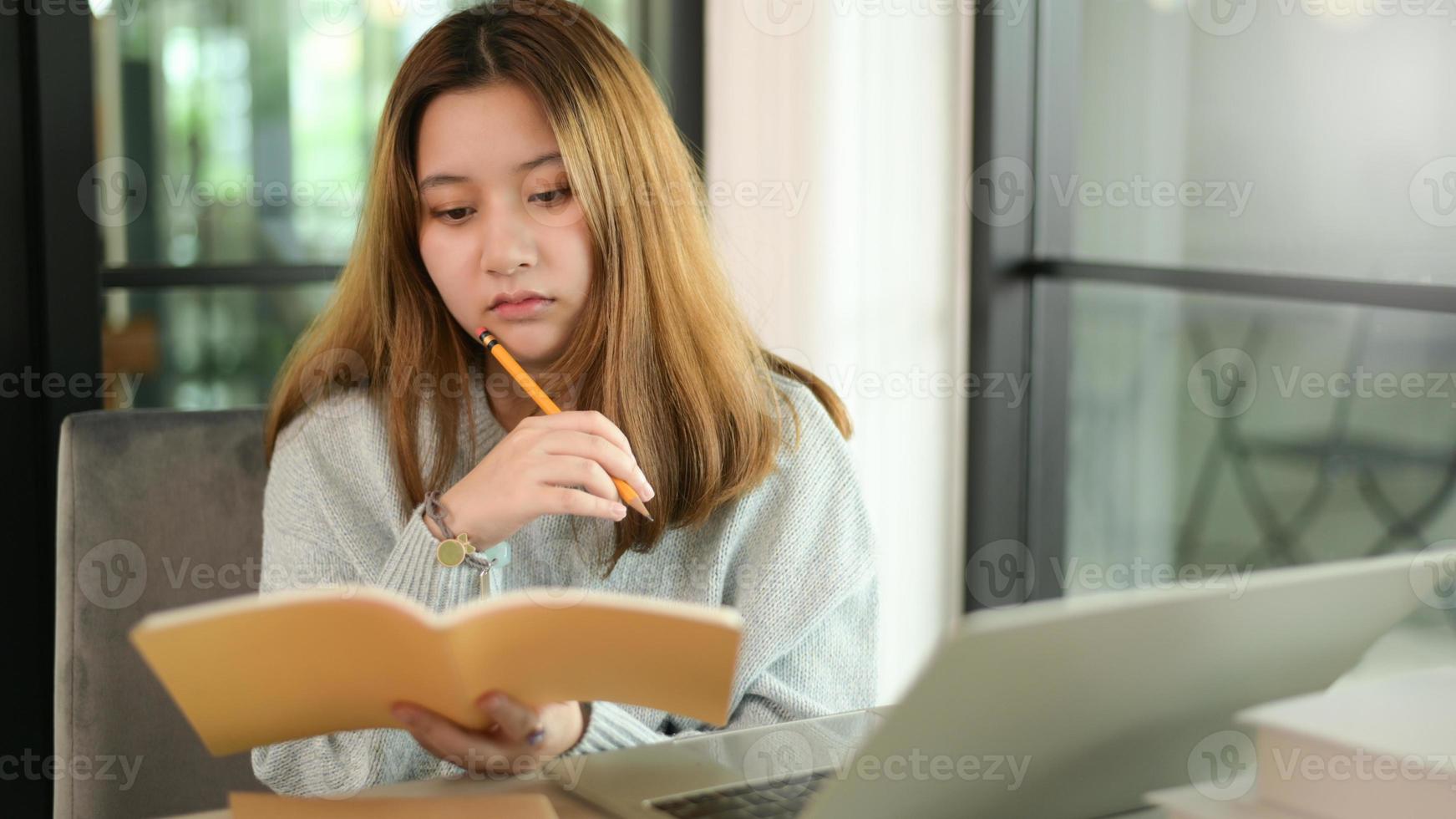 tiener vrouw met potlood en notebook serieus gebaar met laptop. foto