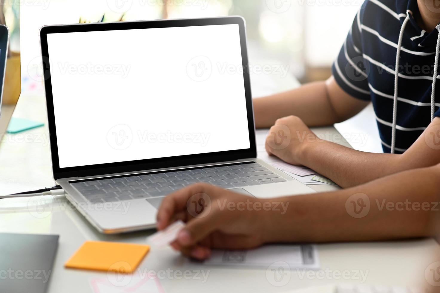 bijgesneden opname van een groep ontwerpers die aan een laptop werken. foto