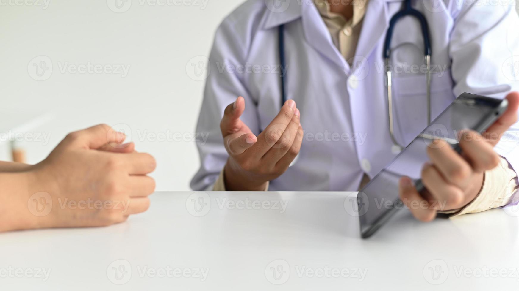medische werkers in laboratoriumjas en stethoscopen gebruiken een tablet. foto