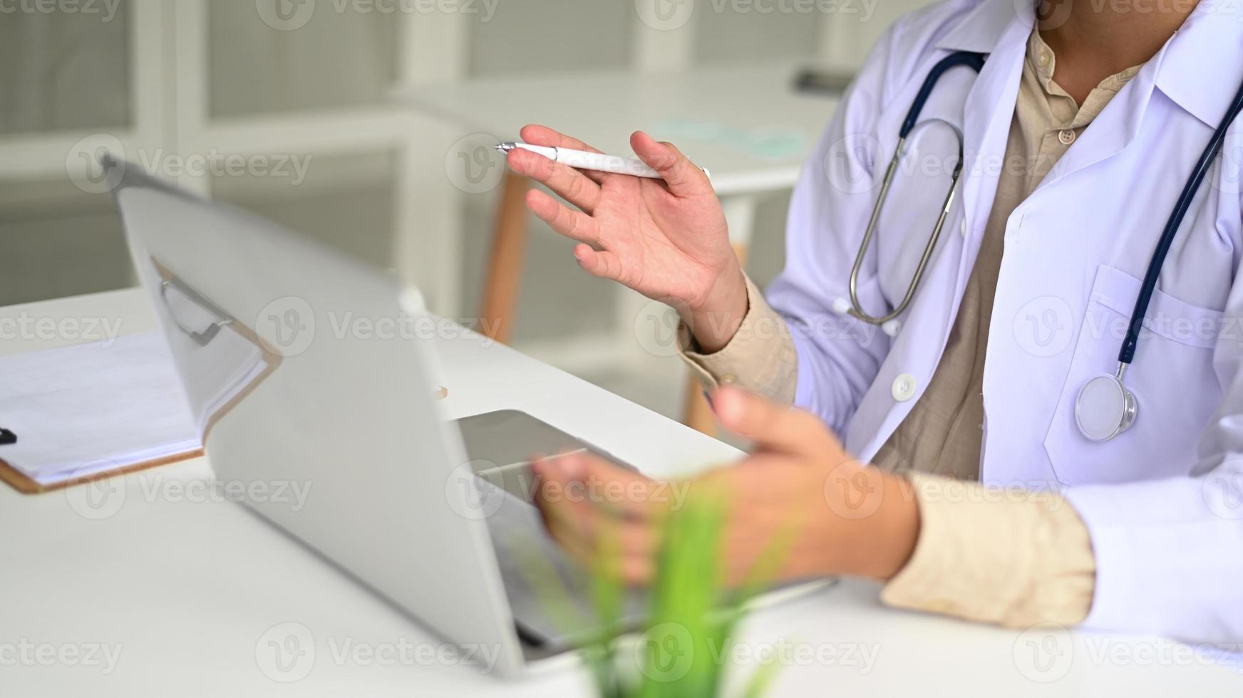 medisch personeel in laboratoriumjas en stethoscopen gebruiken laptopconferenties. foto