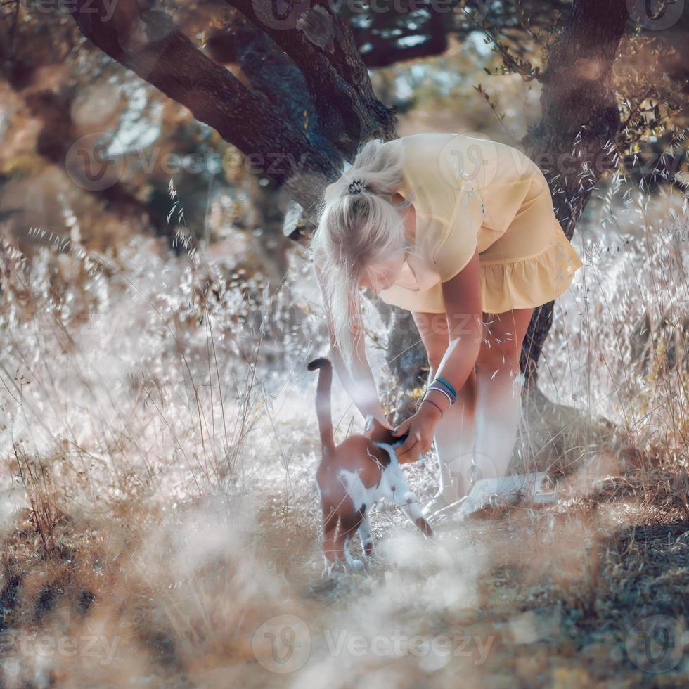 een blonde vrouw op blote voeten in een gele zomerjurk foto