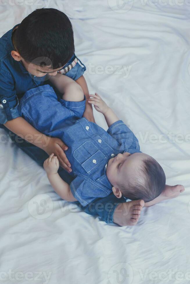 gelukkig kinderjaren concept. gelukkig broers portret. 6 jaren en 6 maanden oud jongens hebben plezier. twee weinig kinderen glimlachen hebben mooi zo tijd. schattig weinig broers aan het liegen en spelen samen foto