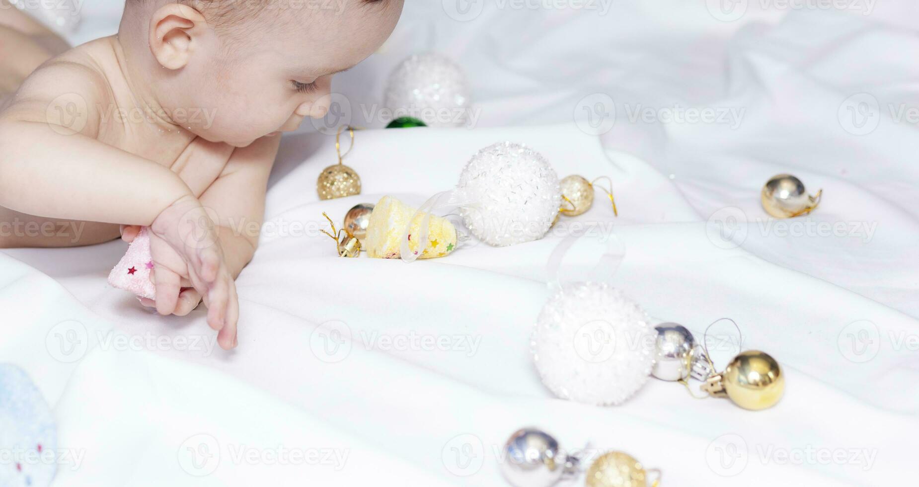 baby jongen spelen met Kerstmis ballen en speelgoed foto