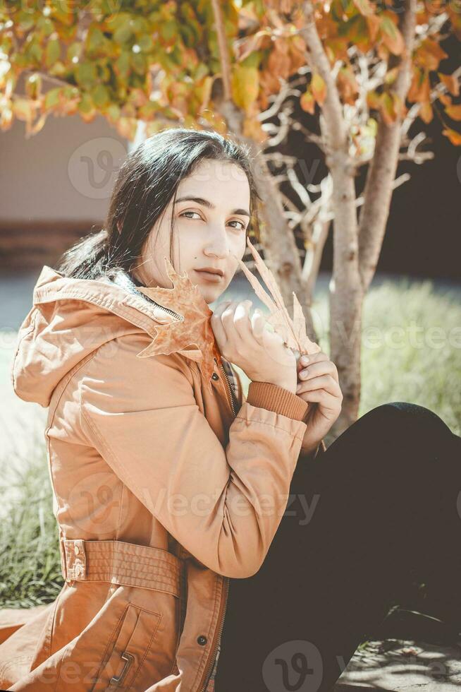 herfst vrouw. vallen seizoen concept. een portret van mooi vrouw met een geel herfst blad foto